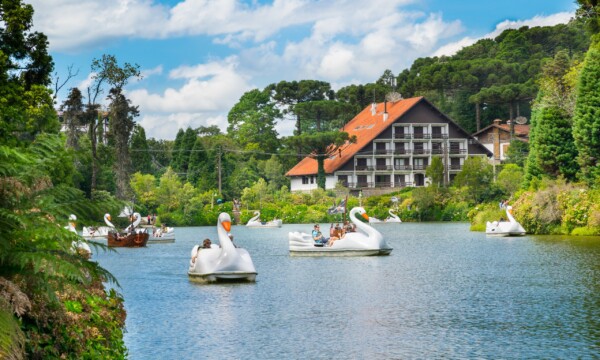 Pessoas passeando em pedalinhos brancos em formato de cisne no Lago Negro, em Gramado.