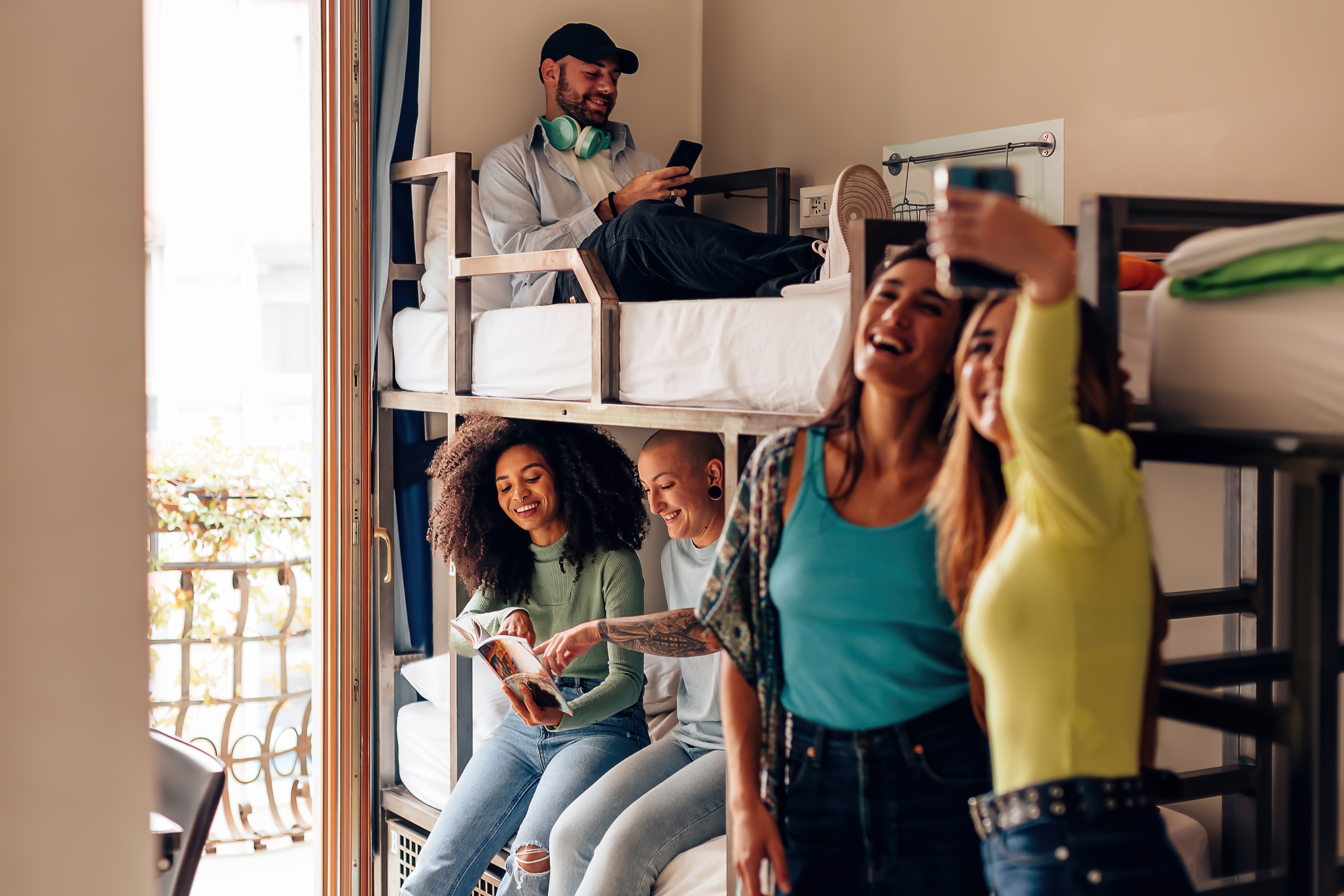 Cinco jovens em quarto de hostel.