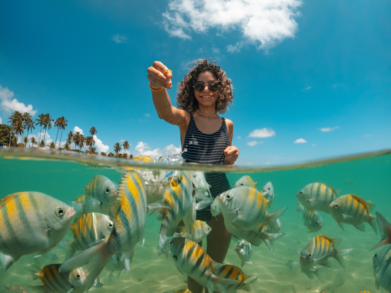 imagem de uma mulher nas piscinas naturais em Posrto de Galinhas, cheia de peixinhos