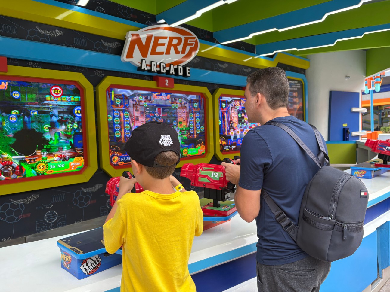 Imagem de um adulto e uma criança brincando na área da Nerf em BCW