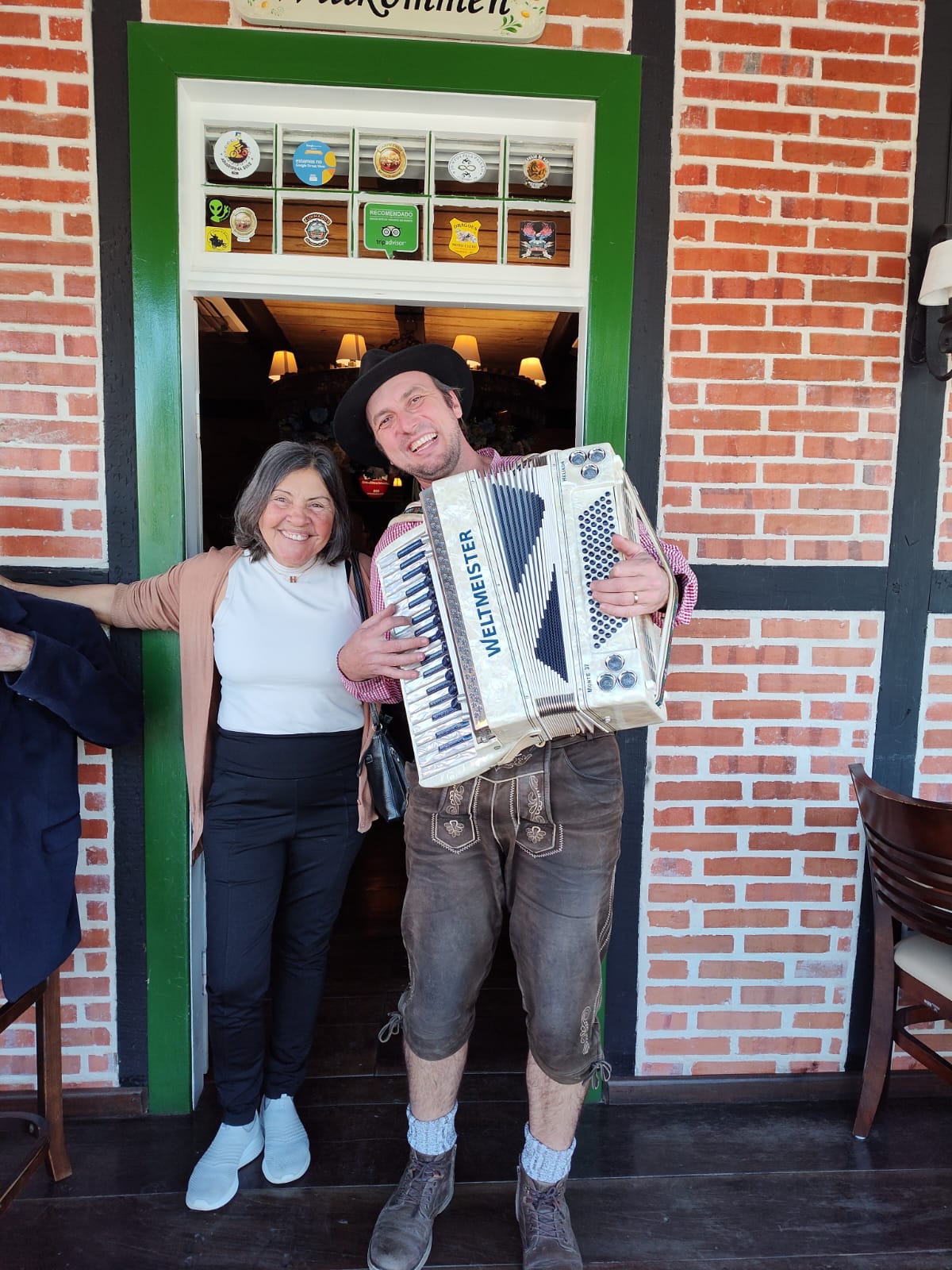 Imagem da entrada com uma mulher e o músico do Wunderwald, restaurante típico Alemão em Pomerode, SC